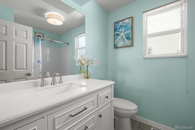 8815 W Quarto Cir, Littleton, CO 80128 - bathroom with toilet, vanity, baseboards, and a shower