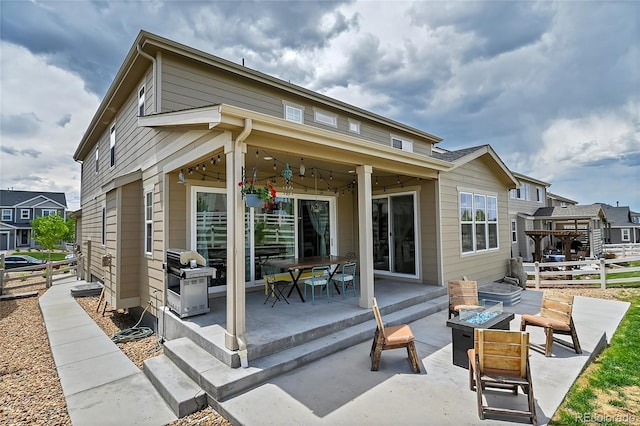 rear view of house featuring a patio area and a fire pit