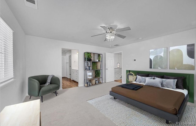 bedroom with ceiling fan, carpet floors, and ensuite bath