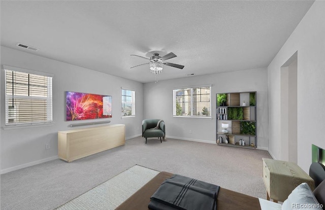 living room featuring ceiling fan, carpet, and a textured ceiling