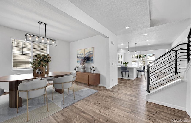 dining space featuring hardwood / wood-style floors and a textured ceiling