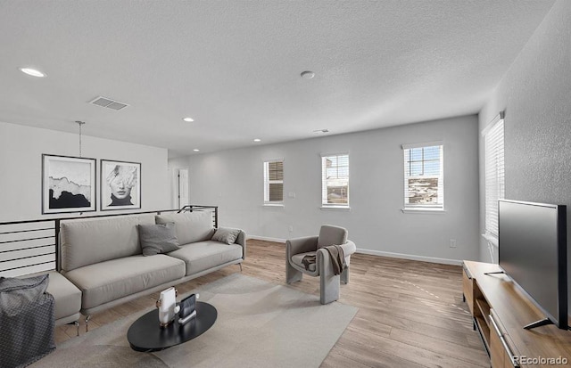 living room featuring a textured ceiling and light wood-type flooring