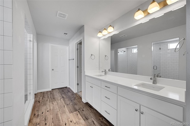 bathroom featuring vanity, hardwood / wood-style floors, and a shower with door