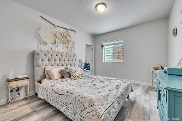 bedroom with hardwood / wood-style flooring and a textured ceiling