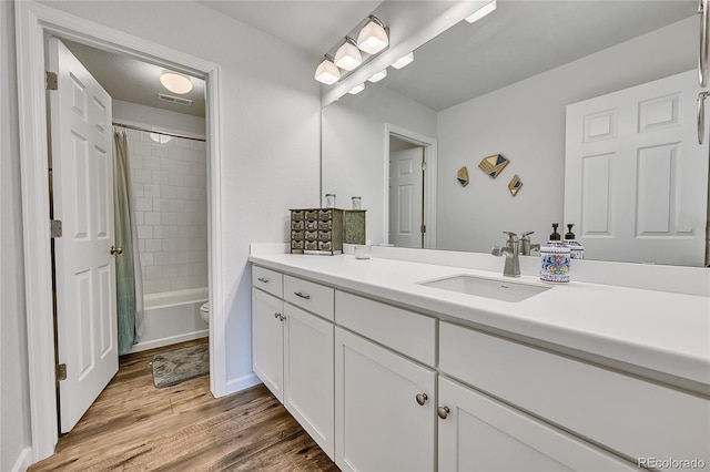 full bathroom featuring vanity, toilet, hardwood / wood-style floors, and shower / bath combo with shower curtain