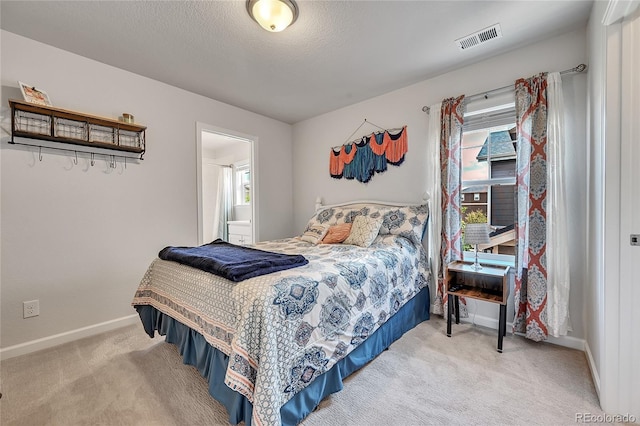 carpeted bedroom featuring multiple windows and a textured ceiling