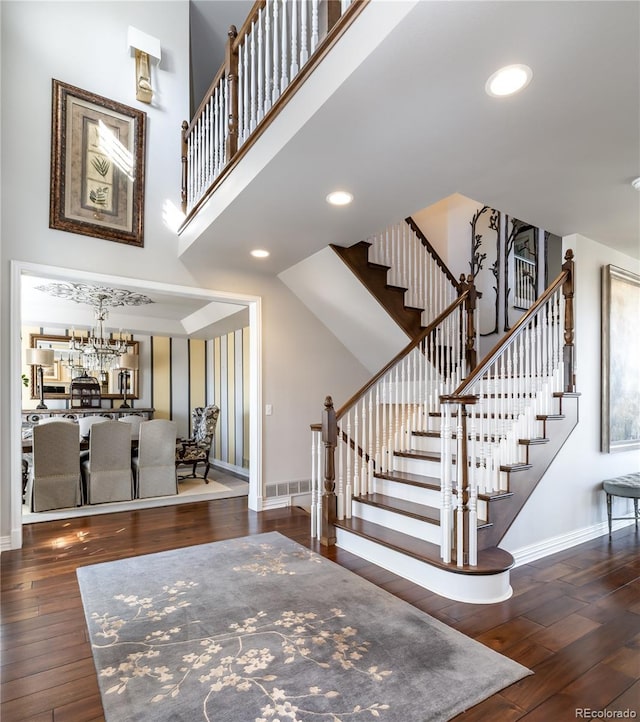 4483 W Cottonwood Pl, Littleton, CO 80123 - stairway with baseboards, wood-type flooring, a chandelier, recessed lighting, and a towering ceiling