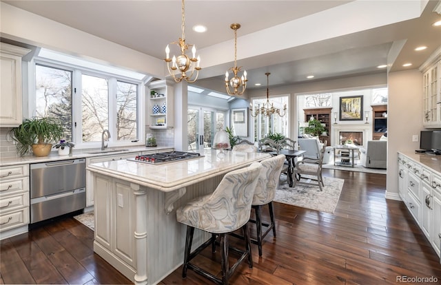 4483 W Cottonwood Pl, Littleton, CO 80123 - kitchen with appliances with stainless steel finishes, a sink, a chandelier, dark wood-style flooring, and backsplash