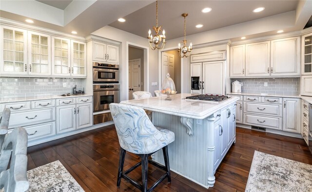 4483 W Cottonwood Pl, Littleton, CO 80123 - kitchen featuring stainless steel appliances, a kitchen breakfast bar, a chandelier, dark wood-style floors, and recessed lighting