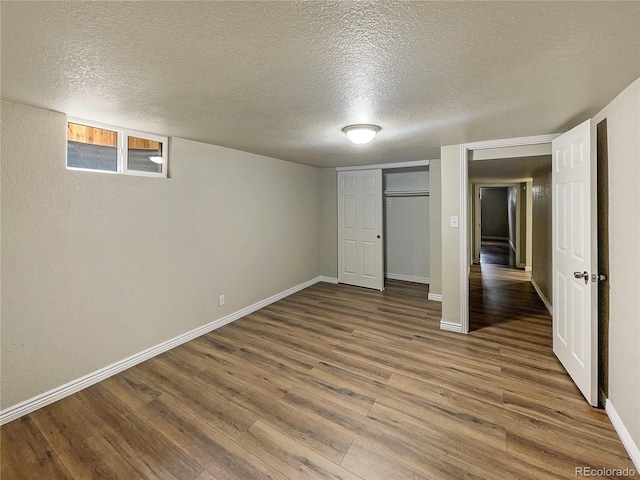 basement featuring a textured ceiling and hardwood / wood-style flooring