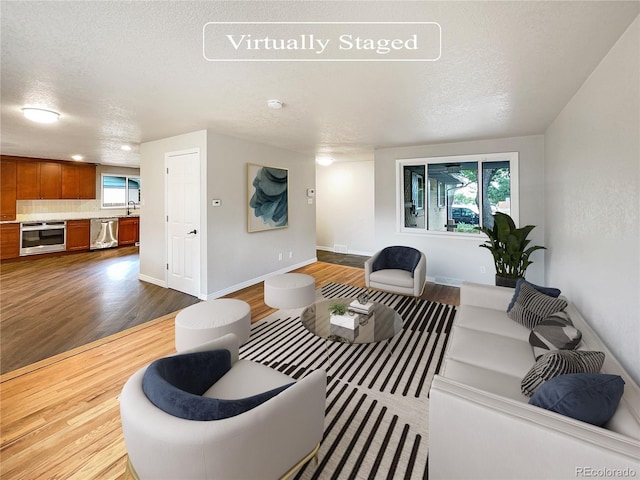 living room with hardwood / wood-style flooring, plenty of natural light, and a textured ceiling