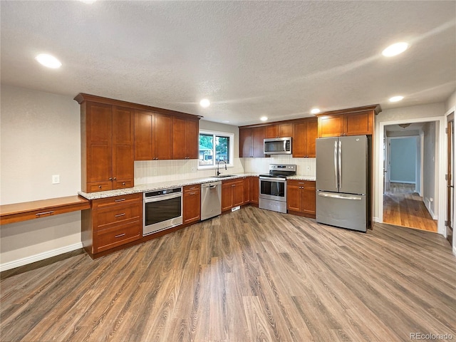 kitchen with decorative backsplash, appliances with stainless steel finishes, dark hardwood / wood-style floors, and sink