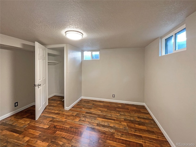 basement featuring dark hardwood / wood-style flooring and a textured ceiling