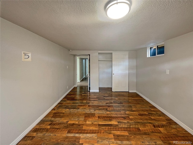 unfurnished room with a textured ceiling and dark wood-type flooring