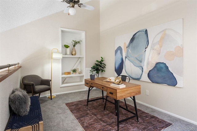 carpeted home office with vaulted ceiling, ceiling fan, baseboards, a textured ceiling, and built in features