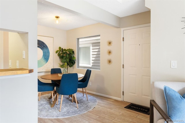 dining room featuring light wood finished floors and baseboards