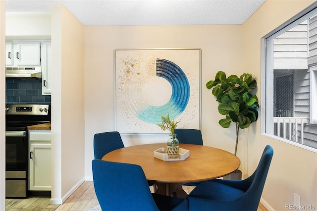dining space featuring light wood-style floors and baseboards