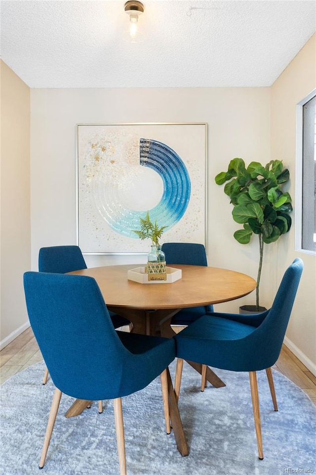 dining area with a textured ceiling and baseboards