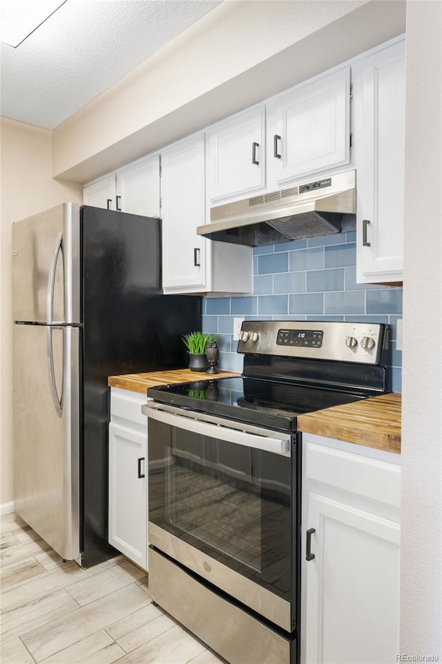 kitchen featuring stainless steel electric range oven, under cabinet range hood, butcher block counters, decorative backsplash, and white cabinets