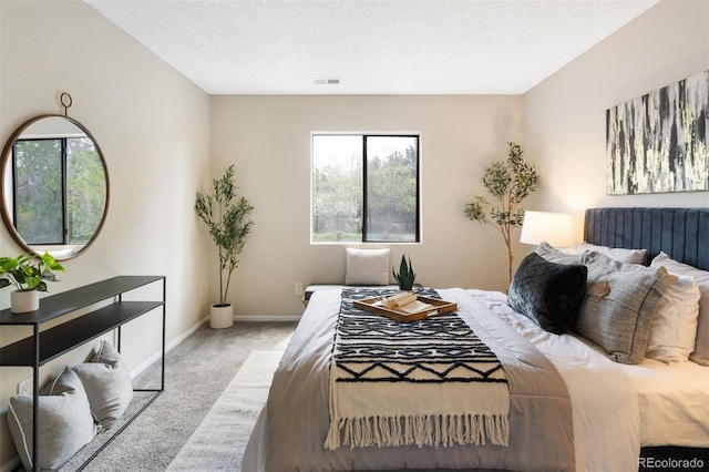 bedroom with carpet, baseboards, and a textured ceiling