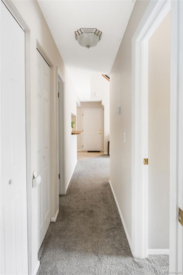 corridor featuring carpet flooring and baseboards