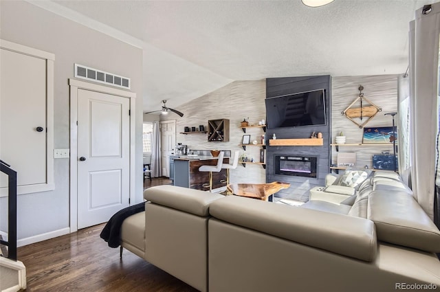 4063 S Quintero Way, Aurora, CO 80013 - living room featuring wood finished floors, a glass covered fireplace, baseboards, vaulted ceiling, and ceiling fan