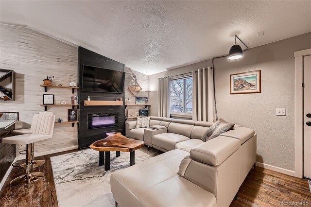 4063 S Quintero Way, Aurora, CO 80013 - living area with a textured ceiling, a textured wall, baseboards, wood finished floors, and a fireplace