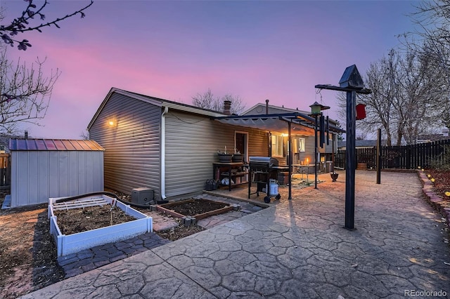 4063 S Quintero Way, Aurora, CO 80013 - back of house with a garden, a patio, a fenced backyard, a storage unit, and an outdoor structure