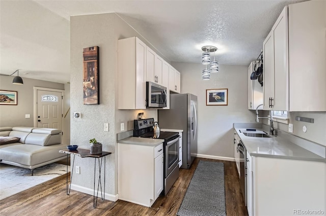 4063 S Quintero Way, Aurora, CO 80013 - kitchen featuring stainless steel appliances, dark wood finished floors, white cabinets, baseboards, and a textured ceiling