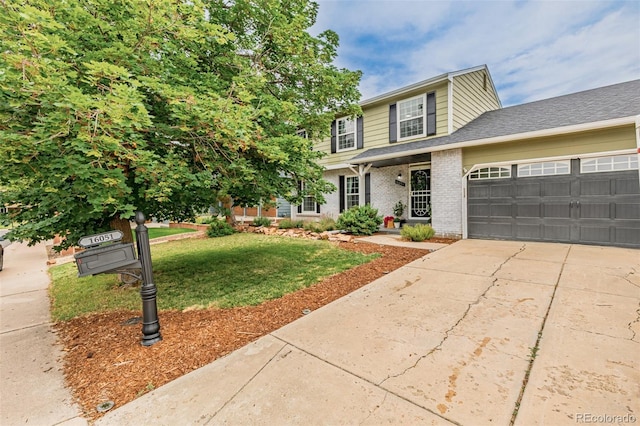 16051 E Alabama Dr, Aurora, CO 80017 - view of front facade featuring driveway, an attached garage, a front lawn, and brick siding