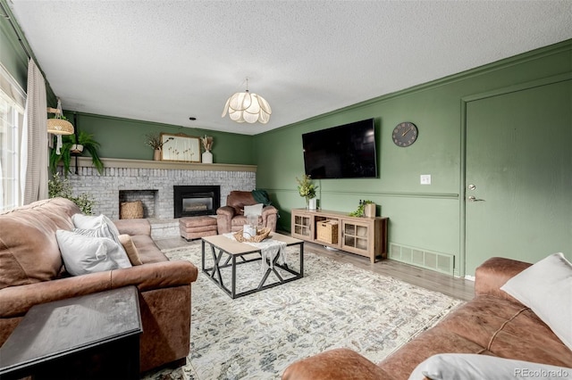 16051 E Alabama Dr, Aurora, CO 80017 - living room with a textured ceiling, a fireplace, a chandelier, and wood finished floors