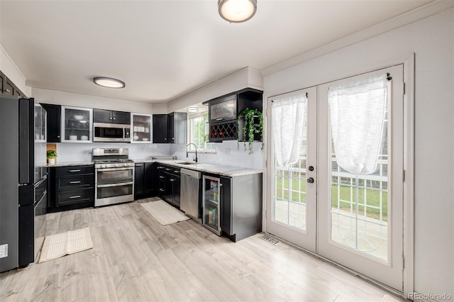16051 E Alabama Dr, Aurora, CO 80017 - kitchen featuring stainless steel appliances, french doors, dark cabinets, ornamental molding, and glass insert cabinets