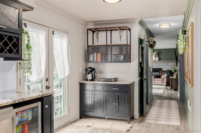 16051 E Alabama Dr, Aurora, CO 80017 - indoor bar with beverage cooler, light wood-style flooring, a fireplace, dishwasher, and crown molding