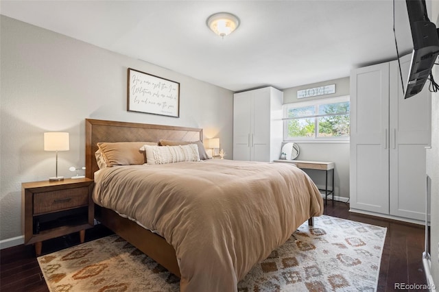bedroom with dark wood finished floors and baseboards