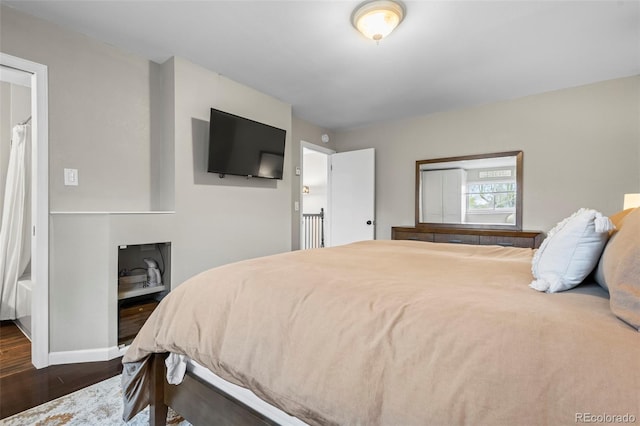 bedroom with dark wood-style flooring and baseboards