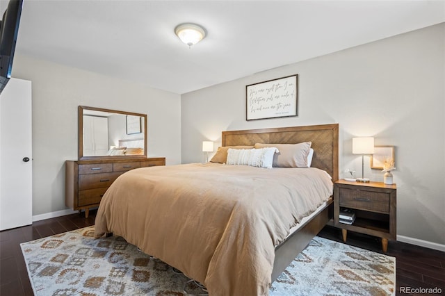 bedroom featuring dark wood-style flooring and baseboards