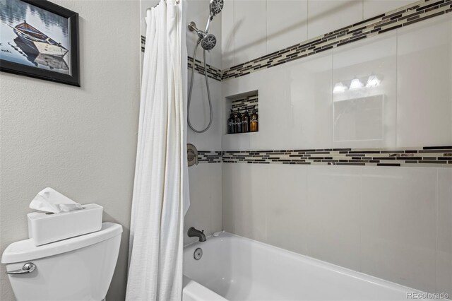 bathroom with toilet, shower / tub combo, and a textured wall