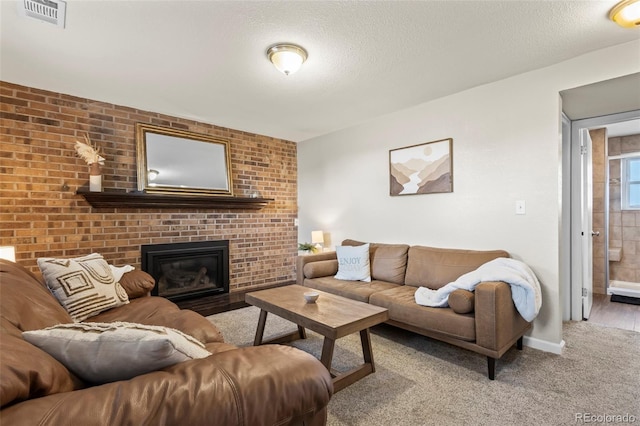 living area featuring a fireplace, visible vents, and a textured ceiling