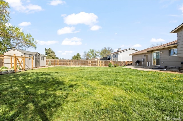 view of yard featuring a fenced backyard, a patio area, a shed, and an outbuilding
