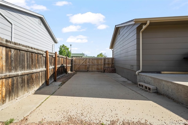view of home's exterior with a patio, fence, and a gate