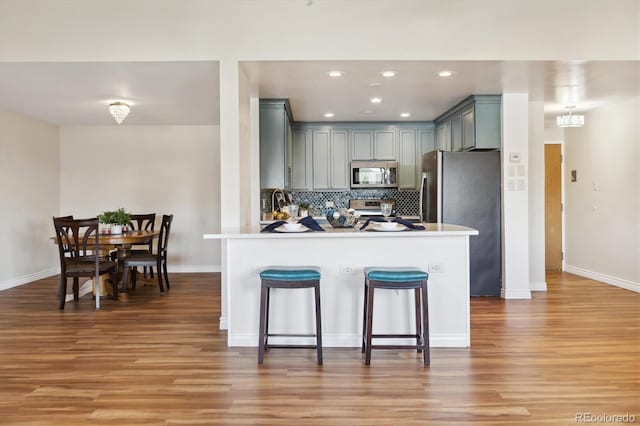 kitchen featuring kitchen peninsula, stainless steel appliances, and light wood-type flooring