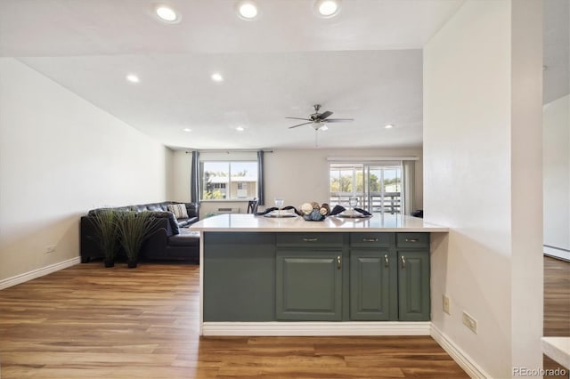 kitchen featuring light hardwood / wood-style flooring, kitchen peninsula, and ceiling fan