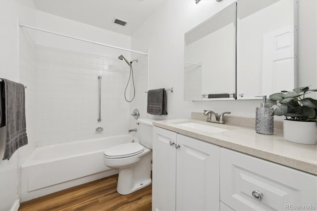 full bathroom featuring toilet, tiled shower / bath, hardwood / wood-style flooring, and vanity