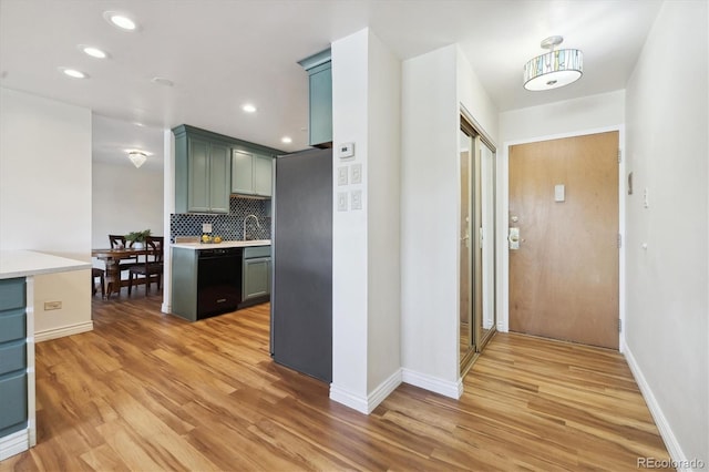 corridor featuring recessed lighting, light wood-type flooring, baseboards, and a sink