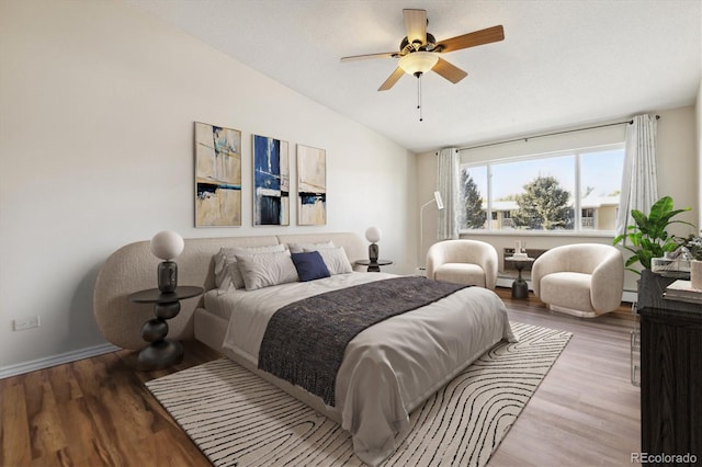 bedroom with vaulted ceiling, wood finished floors, baseboards, and ceiling fan