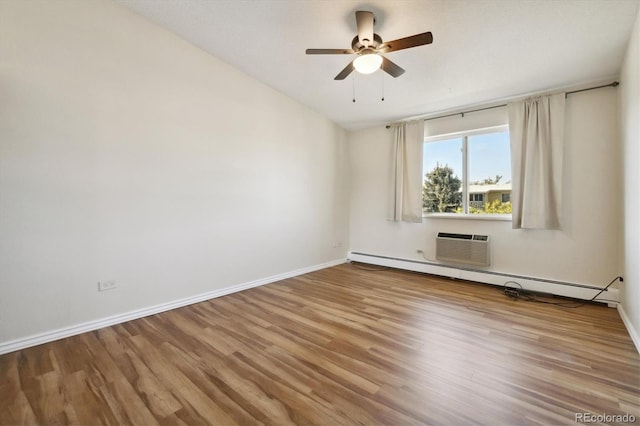 empty room featuring baseboards, wood finished floors, a baseboard radiator, and ceiling fan