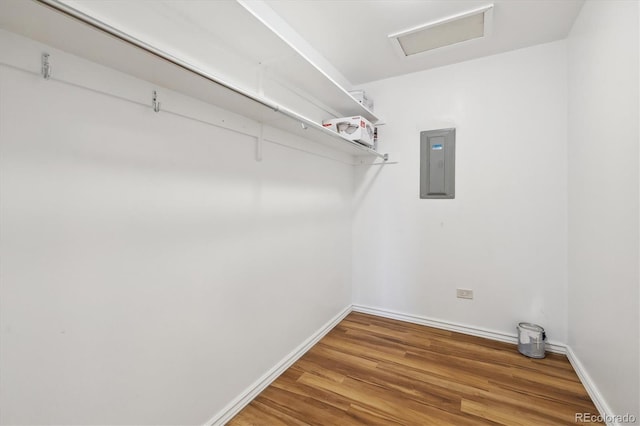 spacious closet featuring electric panel, attic access, and wood finished floors