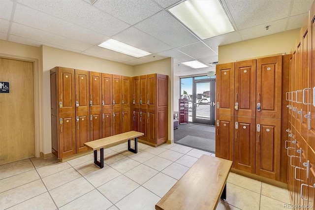 interior space with light tile patterned floors and a drop ceiling