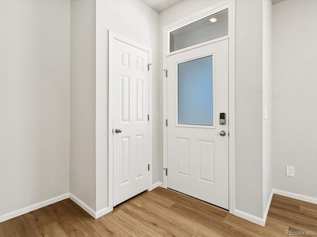 foyer featuring baseboards and light wood-type flooring