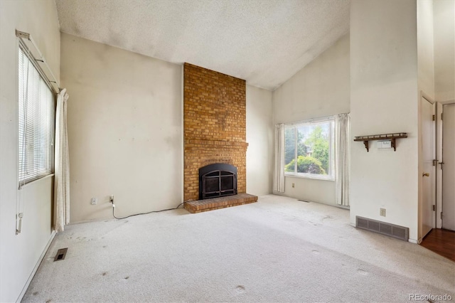 8552 Gray Ct, Arvada, CO 80003 - unfurnished living room with carpet floors, a textured ceiling, high vaulted ceiling, and a fireplace
